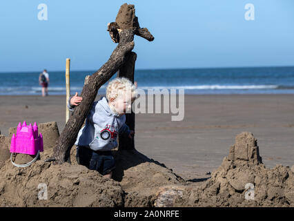 Clementsbrook isaä joue dans un énorme château de sable sur la plage de Whitby, dans le Yorkshire, comme les températures devraient s'élever à 26C dans certaines régions du pays cette semaine. Banque D'Images