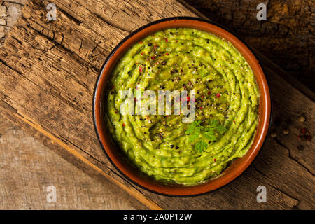 Guacamole maison sauce à l'avocat dans un bol rustique haut Banque D'Images