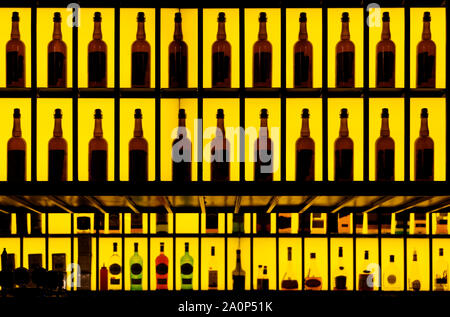 Diverses bouteilles d'alcool dans un bar, l'éclairage jaune retour Banque D'Images