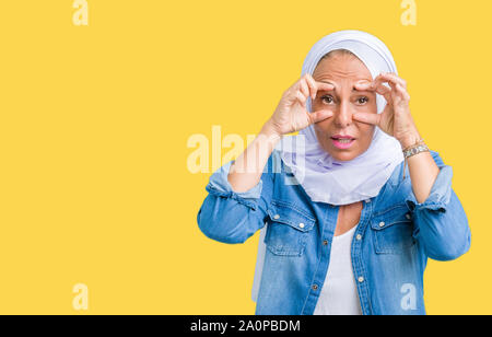 L'âge moyen est de l'arabe arabe femme portant le hijab sur fond isolé d'essayer d'ouvrir les yeux avec les doigts, de somnolence et de fatigue La fatigue du matin Banque D'Images