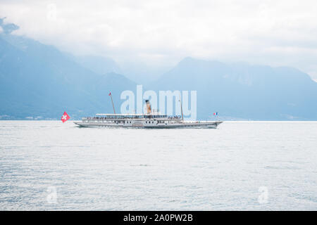 Le plus ancien bateau à aubes à vapeur Belle Epoque passage Montreux Lac Léman) entre la Suisse et la France avec en arrière plan les montagnes des Alpes Banque D'Images