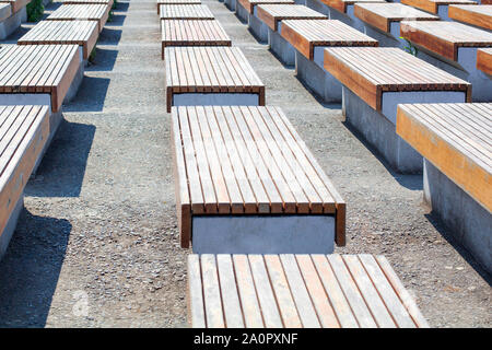 Des bancs vides et en bois sur une surface en béton, prendre la parole à plusieurs lignes de la rue dans le parc sur le bitume, personne n'est là, le soleil, l'été, Close up Banque D'Images