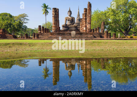 Vue de la sculpture d'un Bouddha assis sur les ruines d'un temple bouddhiste Wat Chana Songkram lors d'une journée ensoleillée. Le parc historique de Sukhothai, Thaïlande Banque D'Images