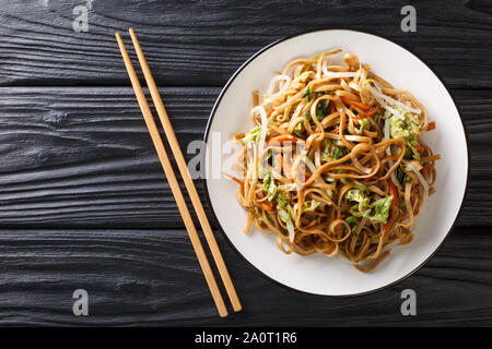 Chinois classique poêlée de nouilles chow mein aux légumes close-up sur une plaque sur la table. Haut horizontale Vue de dessus Banque D'Images