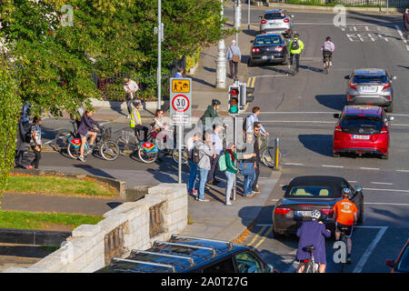 Les cyclistes pour se rendre à son travail sur les Vélos Les vélos attendre aux feux de circulation en piste cyclable, Dublin, Irlande. L'heure de pointe dans la voie cyclable sur sunny day Banque D'Images