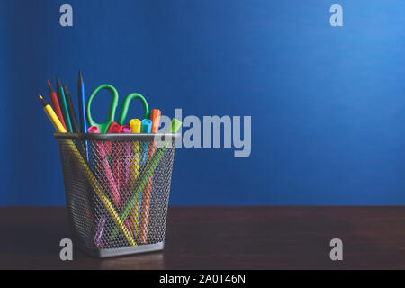 Des études des étudiants et écoliers accessoires. Concept Retour à l'école. Crayons et feutres sur fond bleu Banque D'Images