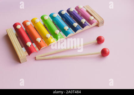 Xylophone jouet en bois de couleur arc-en-ciel sur rose bacground. toy glockenspiel en métal et bois Banque D'Images