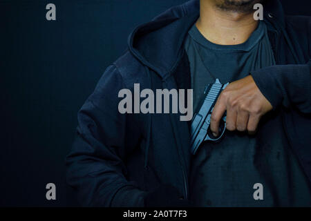 Asian man holding a gun. Fusil à la main arrière-plan d'un blouson de cuir Banque D'Images