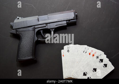 Ensemble de cartes à jouer et de fusil isolé sur fond noir concept casino. Banque D'Images