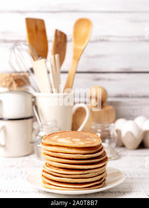 La cuisson des crêpes. Ingrédients, vaisselle et ustensiles de cuisine pour des crêpes. Focus sélectif. Banque D'Images