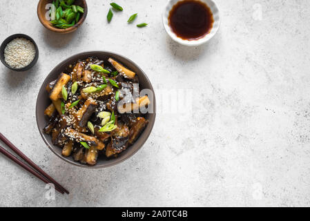 Aubergines sautées dans un bol. Chinois, Coréen ou asiatique végétalien - sauté d'aubergines avec de la sauce soja sweet glaze, vue du dessus, copiez l'espace. Banque D'Images