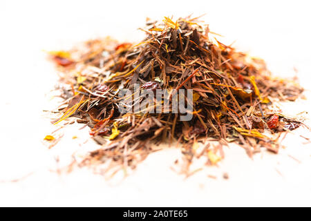 Pile de feuilles de thé rooibos sur fond blanc Banque D'Images