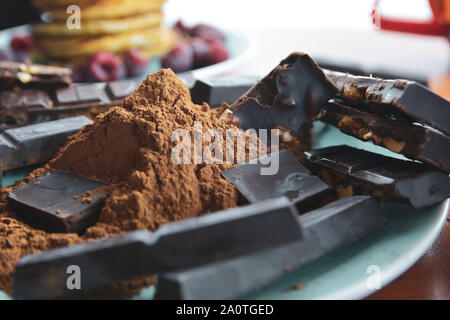 Les barres de chocolat avec du chocolat râpé sur une plaque bleue. Banque D'Images