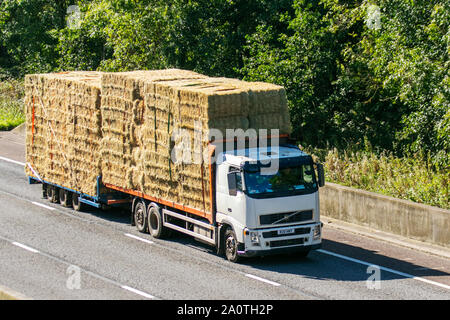 Balles carrées pour la literie animale ; camions lourds de livraison en vrac de transport, transport, camion, transport, camion, fret, véhicule, livraison, transport, industrie, fret, sur la M6 à Lancaster, Royaume-Uni Banque D'Images