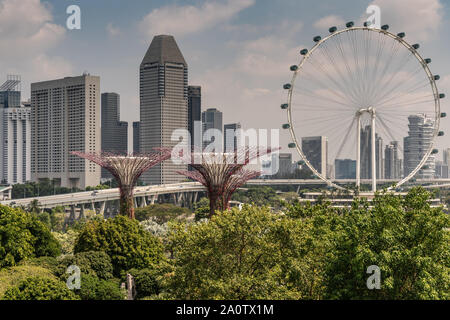 Singapour - Mars 22, 2019 : Jardins de la baie, Supertree Grove. Le flyer Grande Roue et quelques supertrees en face de freeway et gratte-ciel downt Banque D'Images