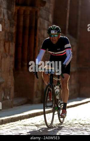 Cycliste sur route pavée à côté de la cathédrale de Coventry UK Banque D'Images