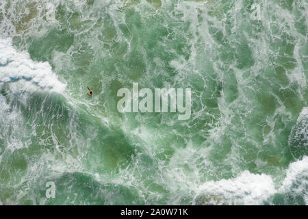 Tout droit tiré de l'homme nage dans les vagues avec de l'eau wite partout. Banque D'Images