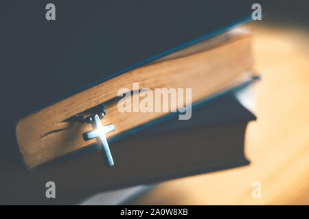 Gros plan du collier croix chrétienne en bois à côté de la Sainte Bible Banque D'Images