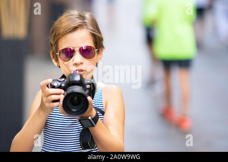 Petite fille en photo avec votre appareil photo reflex numérique on city street Banque D'Images