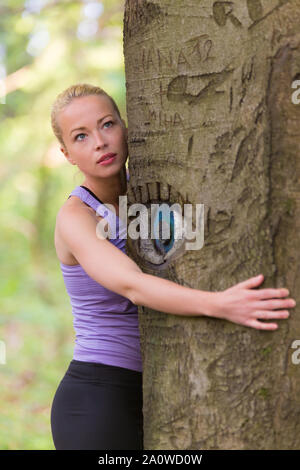 Young woman hugging a tree. Banque D'Images