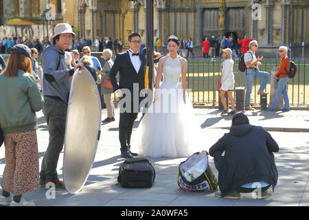 Un couple chinois obtenir leurs photos de mariage prises en face de l'abbaye de Westminster, London, UK Banque D'Images