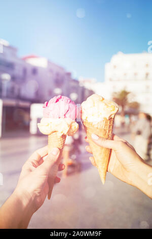 Woman's hands holding ice cream cones gaufre dans. La crème glacée à la mangue et à la fraise. Banque D'Images