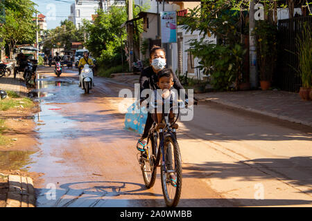 Siem Reap / Cambodge - 25 octobre 2018 : Femme à vélo avec son fils assis sur la barre transversale en Asie Banque D'Images