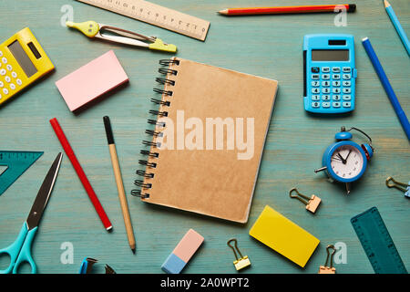 Vue de dessus de l'ordinateur portable marron blanc près de matériel scolaire à table en bois Banque D'Images