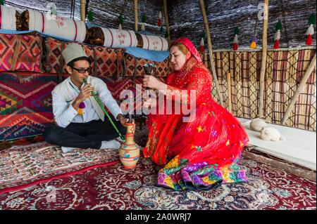 Couple de Qashqai fumer une pipe de l'eau dans une tente, Qashqai camp nomade, la province du Fars, Iran Banque D'Images