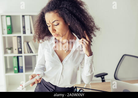 Insatisfait african american woman in office thermomètre Banque D'Images