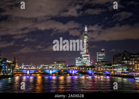 Vue sur la Tamise depuis le pont du Millenium, montrant l'horizon lumineux de Londres la nuit, avec immeubles de bureaux modernes, Southwark Bridge i Banque D'Images