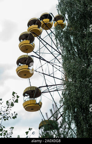 Grande roue jaune rouillé dans un parc d'attractions à Tchernobyl Banque D'Images