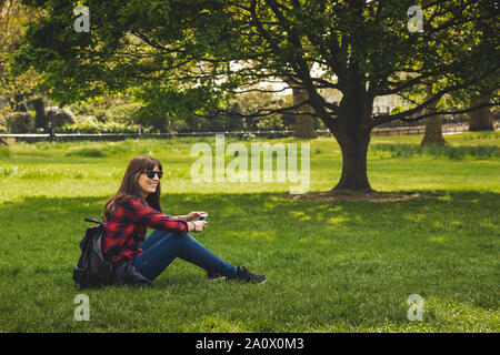 Belle femme assise sur l'herbe du Rhône et relaxant Banque D'Images