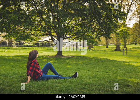 Belle femme assise sur l'herbe du Rhône et relaxant Banque D'Images