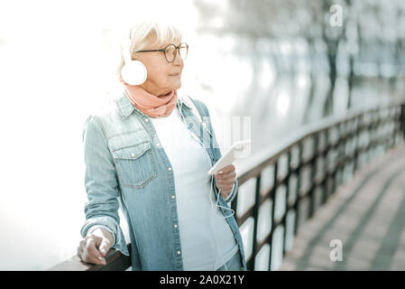 Le vieillissement de charme femme portant un casque massif près de bridge Banque D'Images