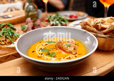 Assiette creuse avec soupe au potiron et un autre aliment, dîner dans un restaurant italien Banque D'Images