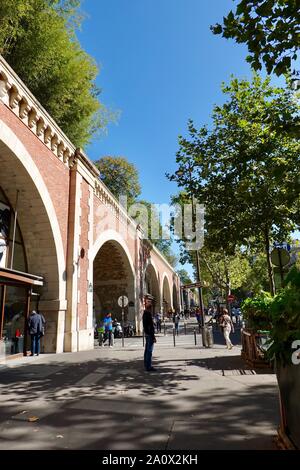 Le niveau de la rue boutiques sous la promenade plantée, une promenade verte dans le 12e arrondissement à la suite de l'ancienne ligne de chemin de fer de Vincennes, Paris, France. Banque D'Images