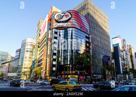 Tokyo, Sukiyabashi carrefour et l'Hulic Ginza Ginza phare bâtiment avec le magasin Gap. Les voitures qui circulent au cours de passage pour piétons. La journée. Banque D'Images