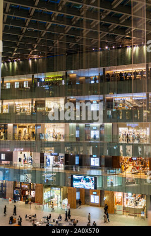 Tokyo, Marunouchi. JP tower KITTE l'intérieur du bâtiment. L'atrium triangulaire, étages de boutiques, toit et rez-de-chaussée coin avec des gens. La nuit. Banque D'Images