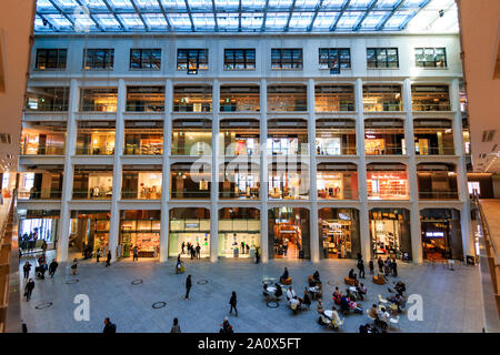 Tokyo, Marunouchi. JP tower KITTE l'intérieur du bâtiment. L'atrium triangulaire, boutiques, toit et rez-de-chaussée coin salon avec des gens assis. La journée. Banque D'Images