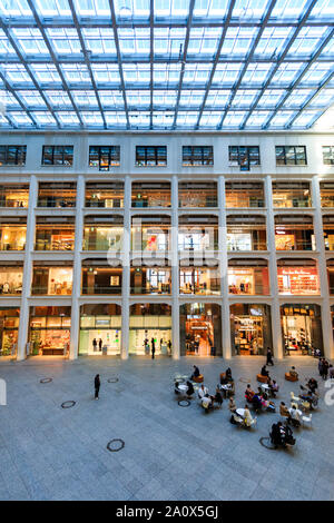 Tokyo, Marunouchi. JP tower KITTE l'intérieur du bâtiment. L'atrium triangulaire, boutiques, toit et rez-de-chaussée coin salon avec des gens assis. La journée. Banque D'Images