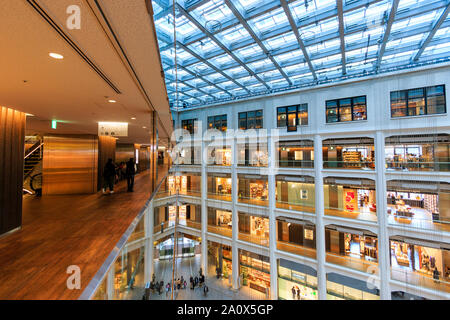 Tokyo, Marunouchi. JP tower KITTE l'intérieur du bâtiment. Vue d'angle de l'allée, atrium triangulaire, boutiques et le toit. La journée. Les gens. Banque D'Images