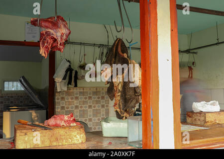 Et l'estomac de boeuf sur crochets de fer dans la boutique simple près de road sur l'île de Java. Boucherie traditionnelle avec de la viande bovine au vendeurs de musulmans en Indonésie. Boutique de la viande. Banque D'Images