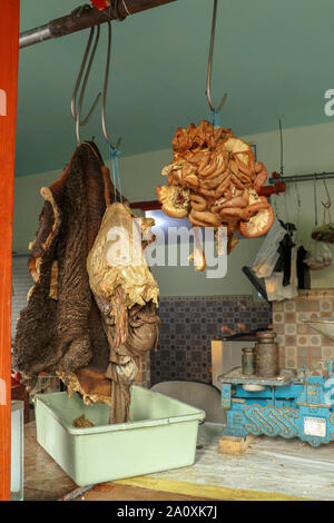 Et l'estomac de boeuf sur crochets de fer dans la boutique simple près de road sur l'île de Java. Boucherie traditionnelle avec de la viande bovine au vendeurs de musulmans en Indonésie. Boutique de la viande. Banque D'Images