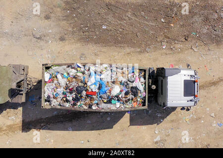 Le déchargement des camions à ordures chargé à une décharge municipale, antenne du haut vers le bas Banque D'Images