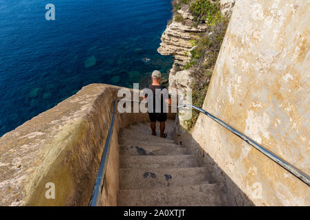 Bonifacio, Corse, France - Sep 19, 2019 : Homme visiteur descendant Roi Aragon étapes. Prise lors d'un après-midi d'été. Banque D'Images