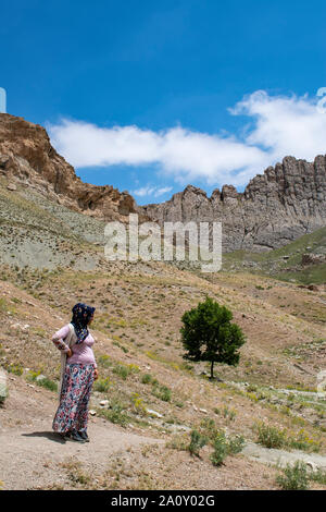 Dogubayazıt : femme kurde en vêtements traditionnels sur le trottoir près du château de vieux Beyazit, l'Ishak Pasha Palace et mosquée Eski Bayezid Cami Banque D'Images