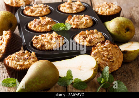 Les délicieux muffins poires aux noix et d'avoine dans un plat allant au four, gros plan sur la table horizontale. Banque D'Images