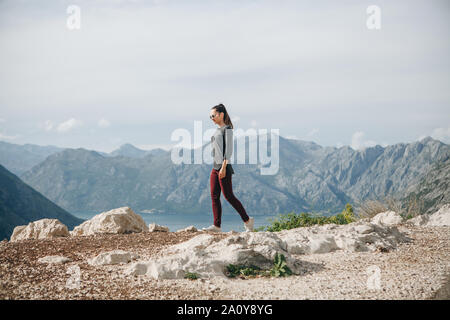 Une fille dans la solitude promenades au sommet d'une montagne dans le contexte d'autres montagnes Banque D'Images