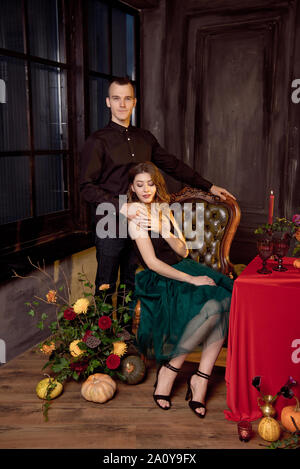 Happy Halloween. Jolie jeune femme et homme de la préparation pour l'Halloween en mettant la table pour un dîner de fête. Banque D'Images